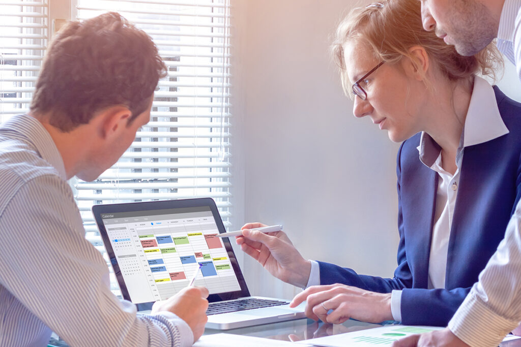 团队在计算机上使用日历计划会议，搜索活动、任务和约会之间的时段，忙碌的商务人士使用时间管E8足球比分具来组织工作，办公室的同事