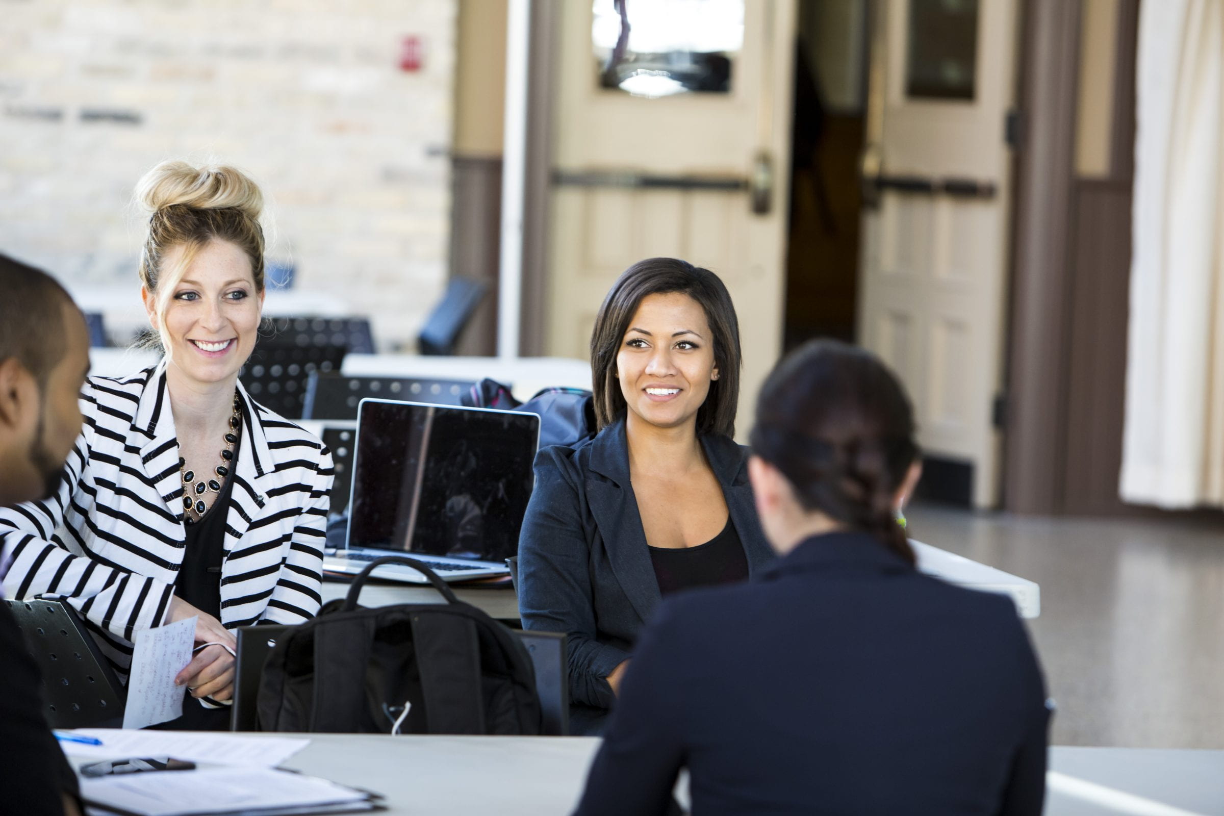 e8体育的学生围坐在学院交换区e8体育网的桌子旁