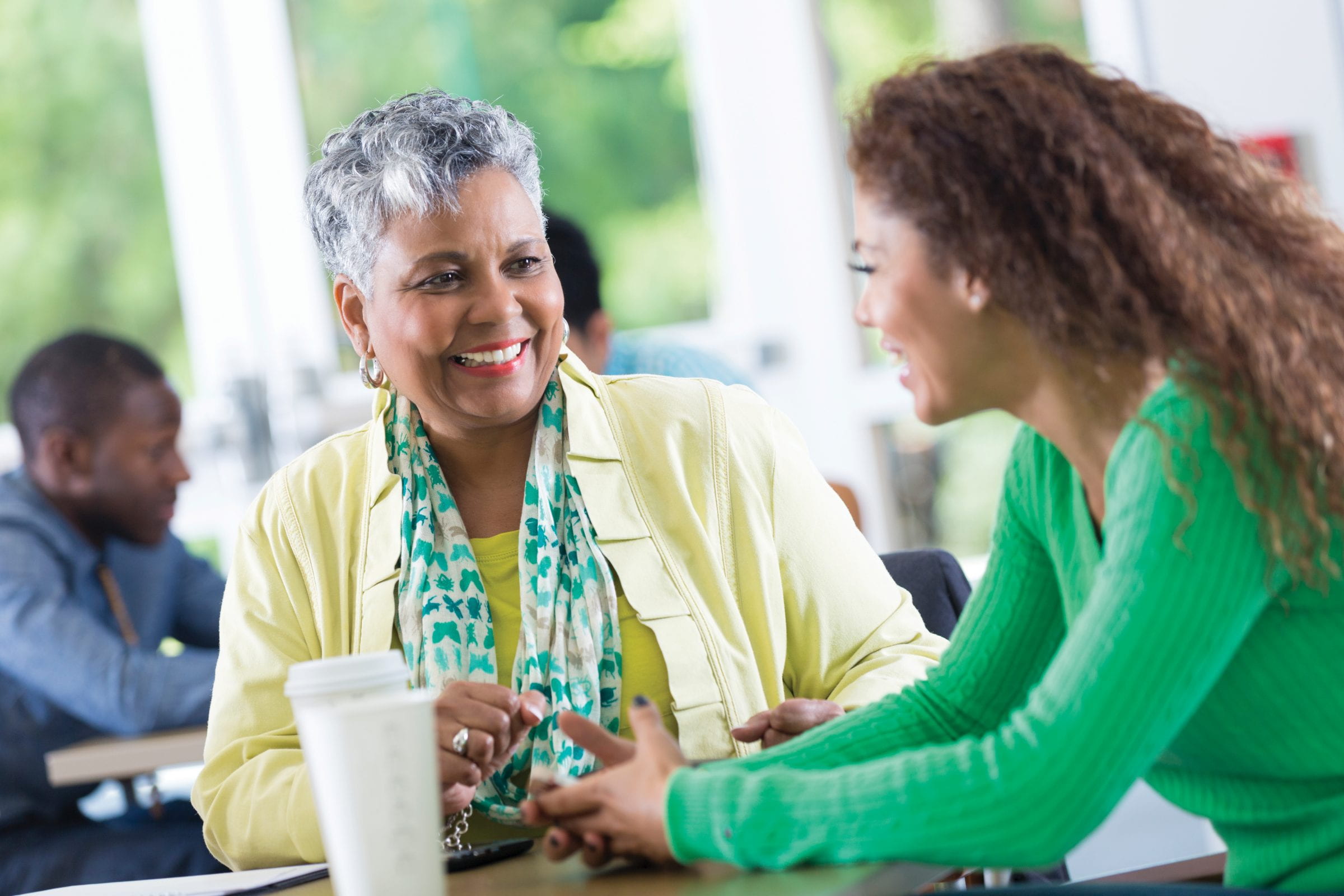 愉快的女商人在工作场所休息室听同事讲话。