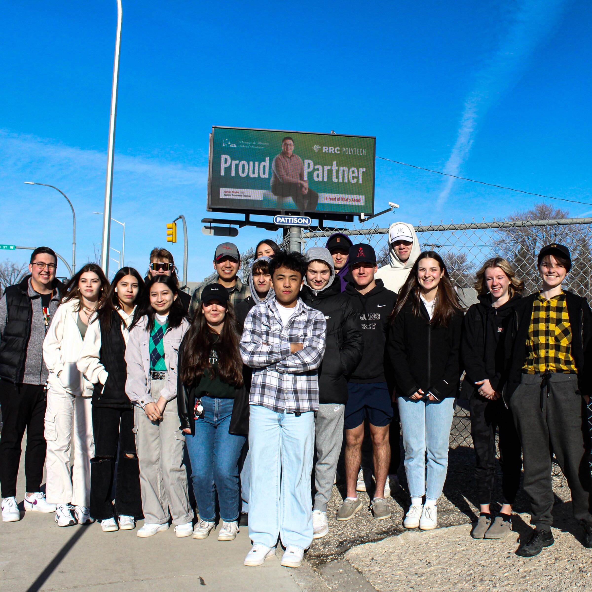 RRC Polytech grad Gavin Taylor (far left) with his grade 12 students on a 'field trip' to see his billboard in Portage la Prairie.