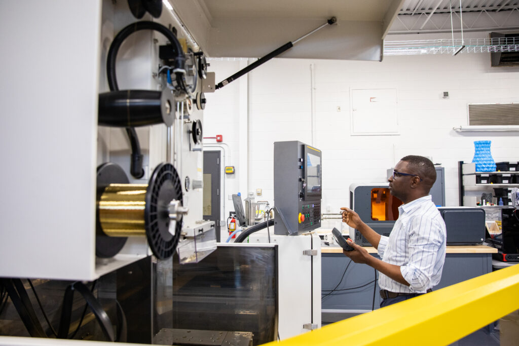 技术实验室中的一个人使用计算机操作大型机器