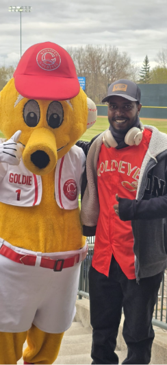 一名 CNI 学生与 Goldeyes 吉祥物合影