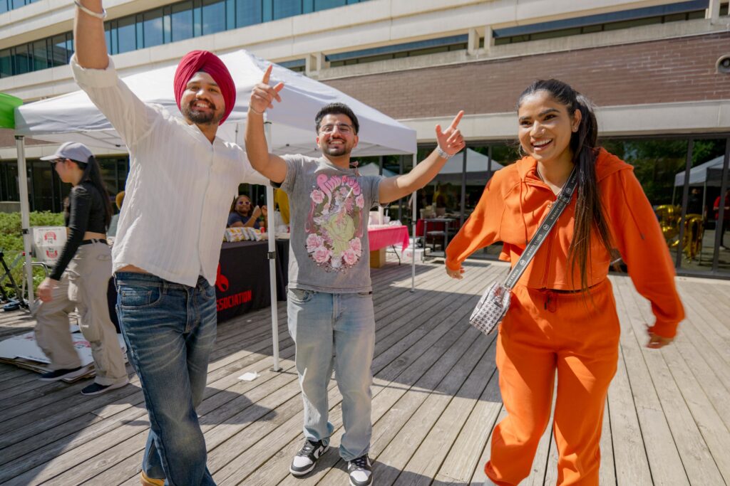 三个人站在一起，对着镜头微笑。