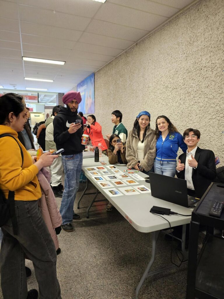 一群人站在桌子后面，摊位上摆着照片和数字显示屏。