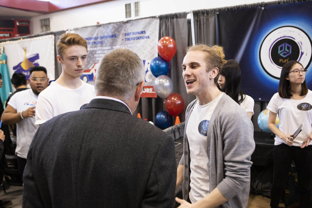 贸易展摊位旁的人们交流