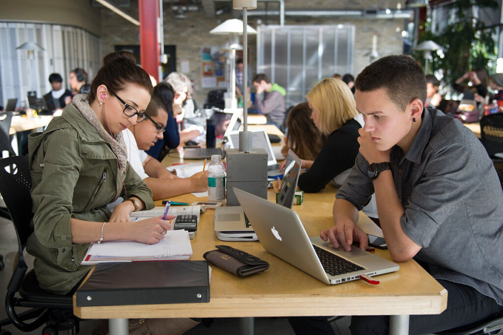 满屋子的学生在笔记本电脑上学习和工作