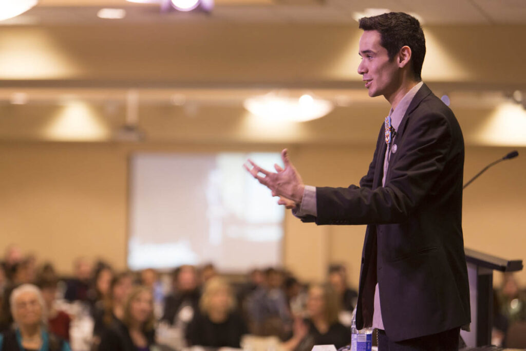 男人在会议上对满屋子的人讲话