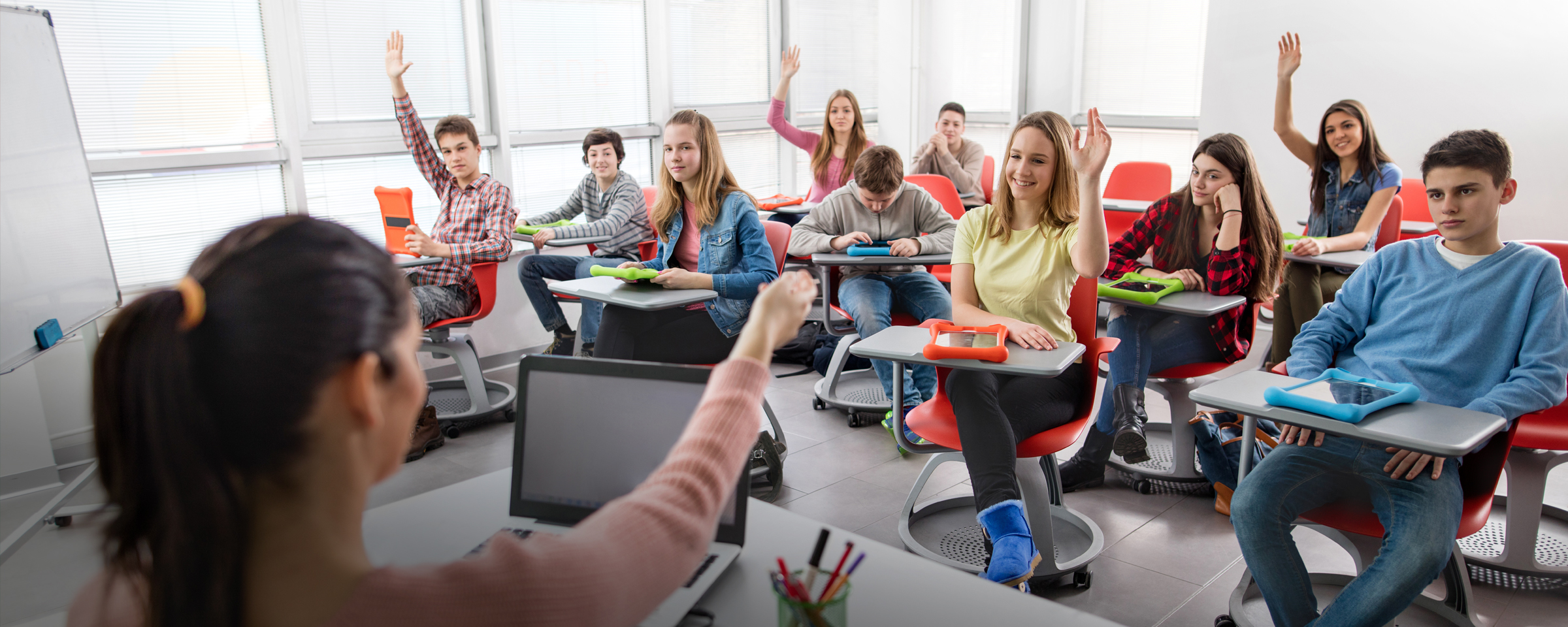 老师在教室前面，学生们举手