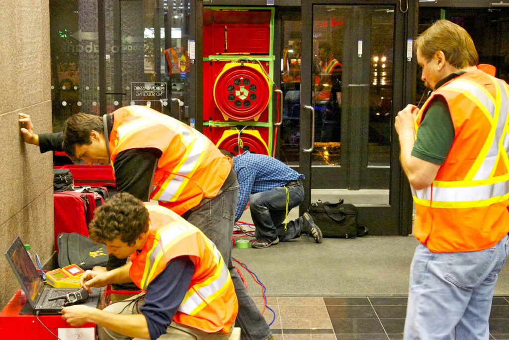 工科学生用笔记本电脑检查建筑工地的墙壁