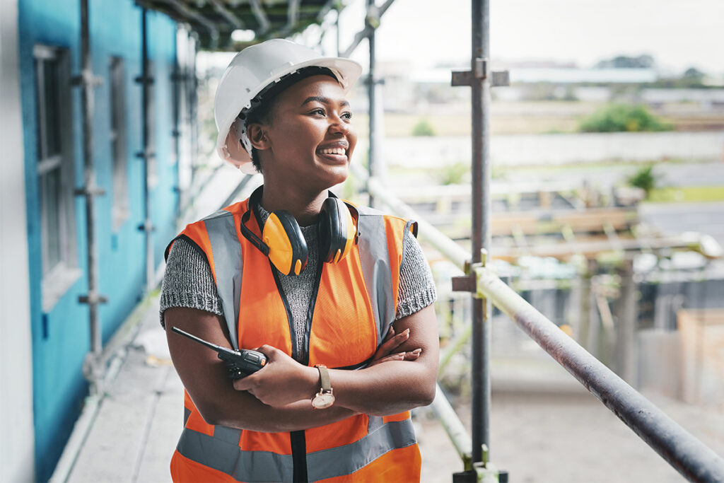 建筑工地穿着橙色安全背心的微笑建筑工人