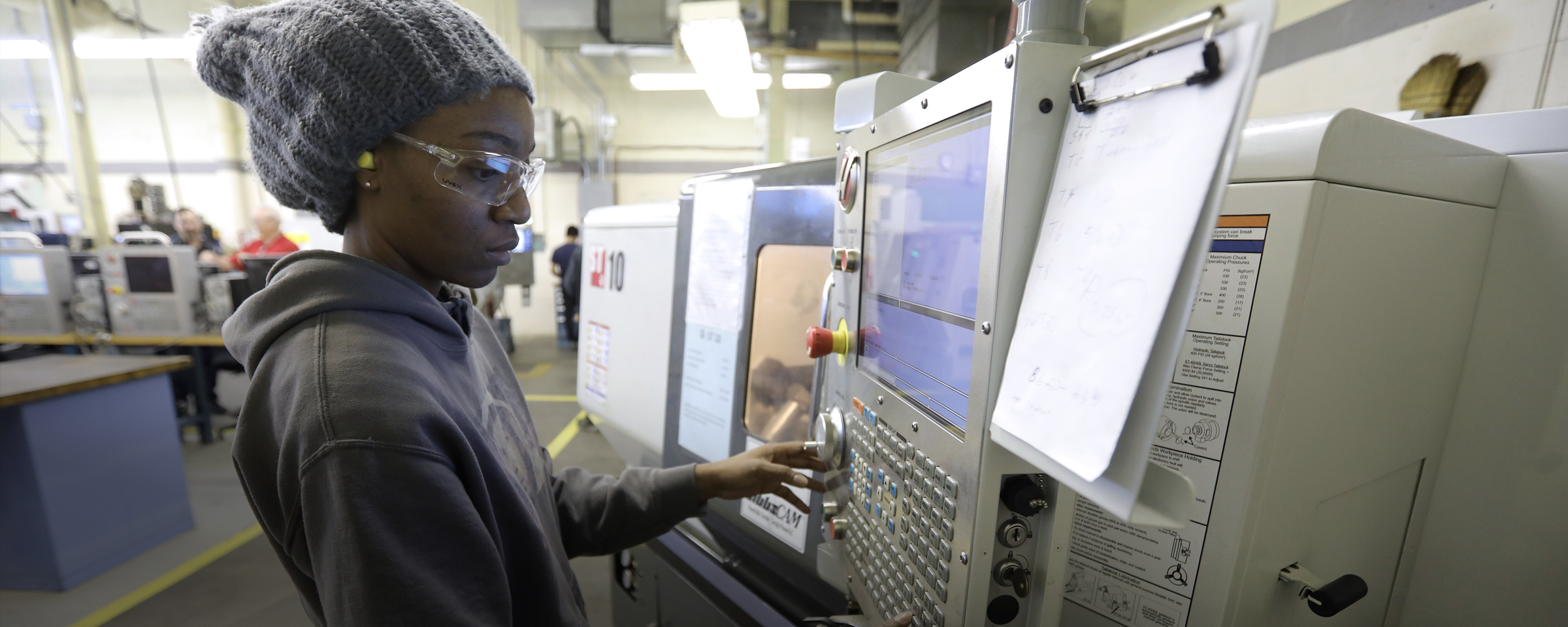 在商店里使用数控机床的学生