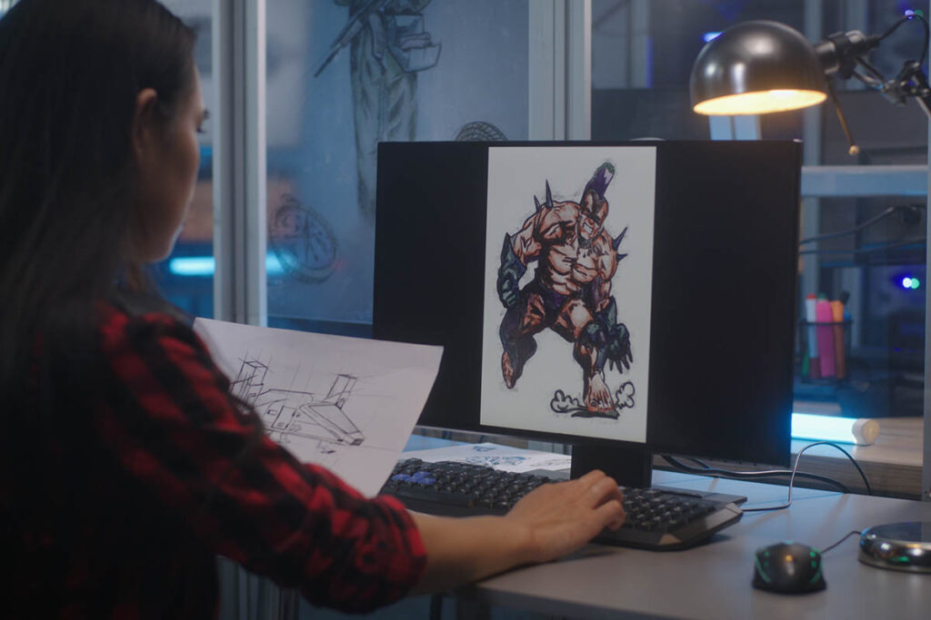 学生根据纸上的参考图在计算机上画一些东西