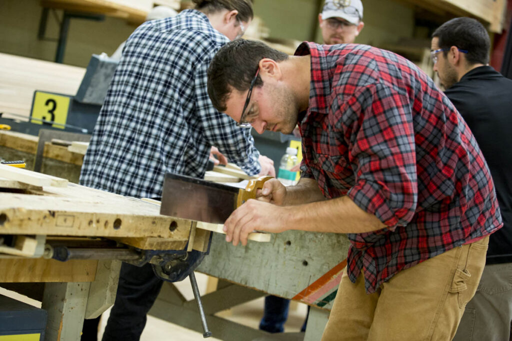 木工学生在木工店锯木