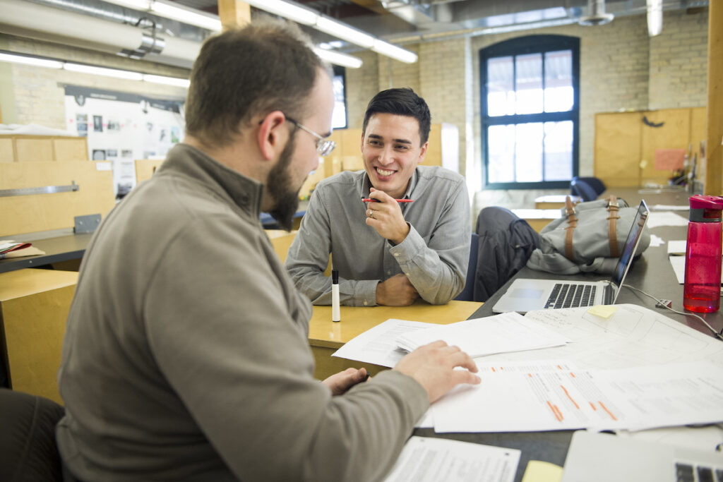 教师在学生设计工作室与学生交谈
