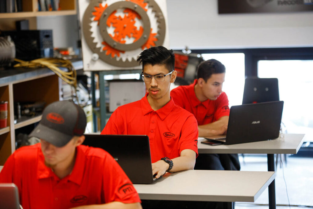 教室里使用笔记本电脑工作的学生