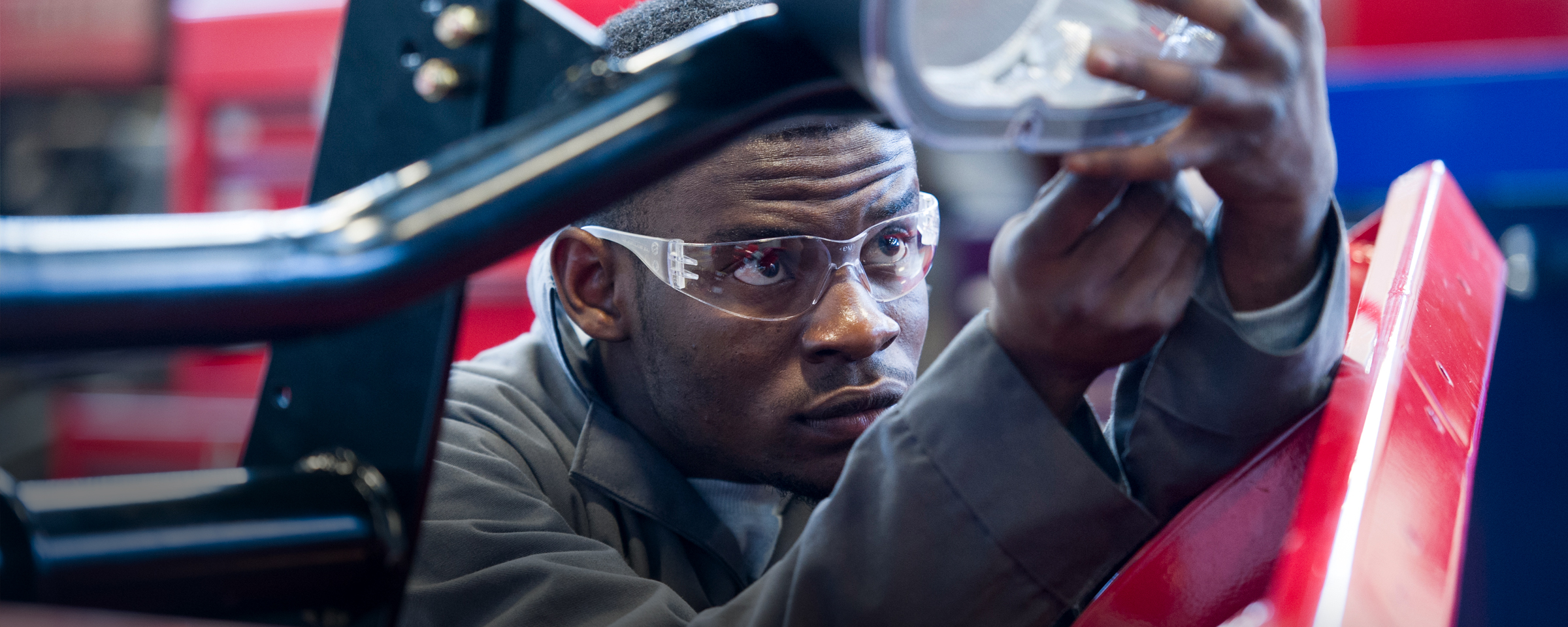 机械学生在已吊起的车辆下方工作