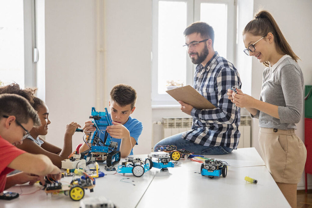 孩子们在教练的观看下组装遥控汽车
