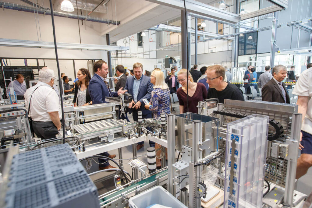 参加行业活动的人们在机器人实验室周围转来转去