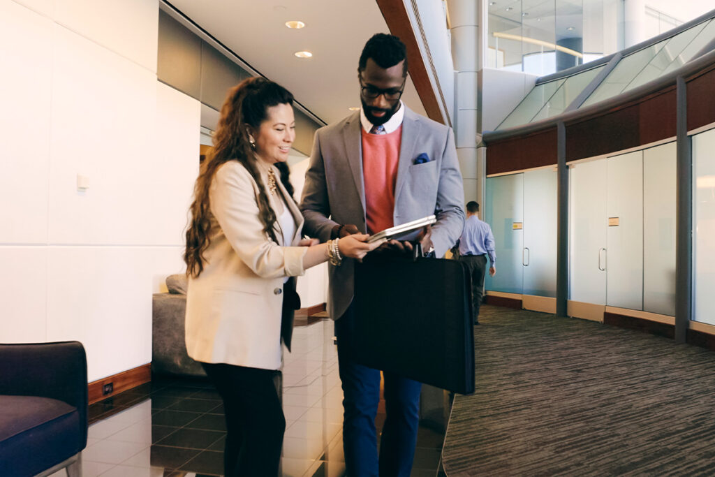 两个人站在一个大门厅里看着笔记本