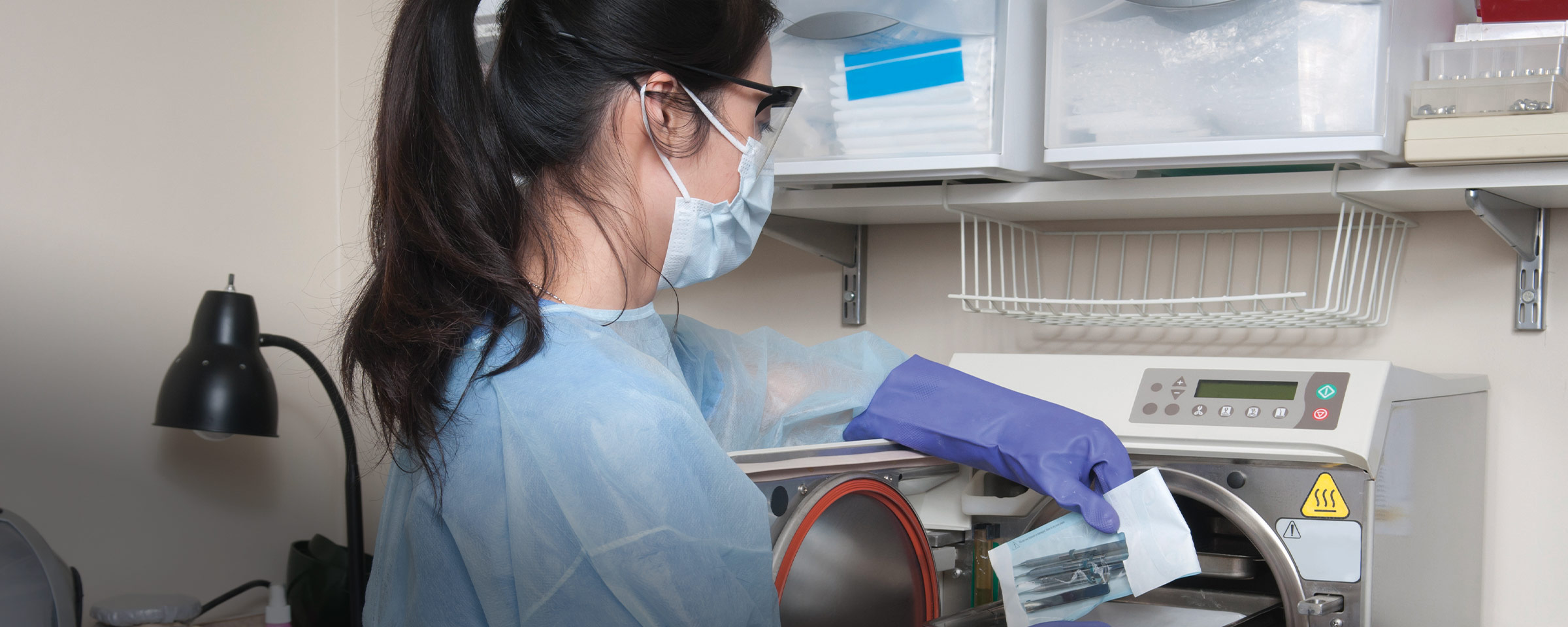 穿着长袍、戴着手术口罩、使用e8体育设备的妇女