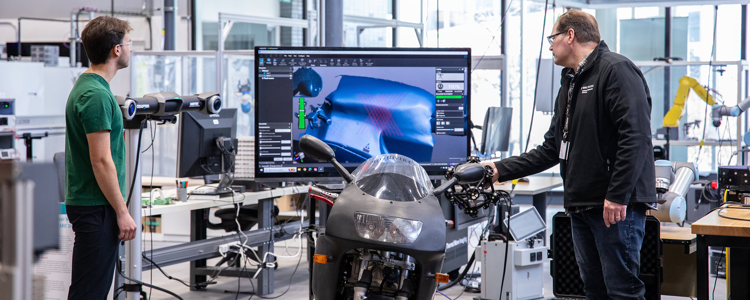 学生和讲师在商店环境中的摩托车上使用 3D 扫描仪。