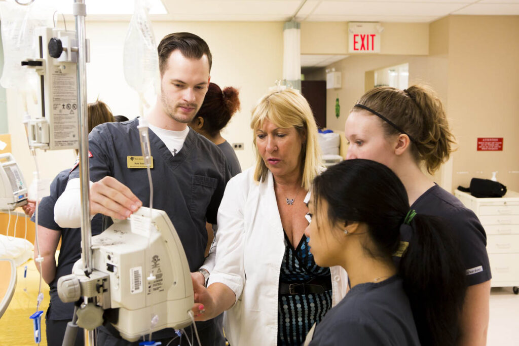 护理讲师向学生展示如何在模拟病房中使用设备