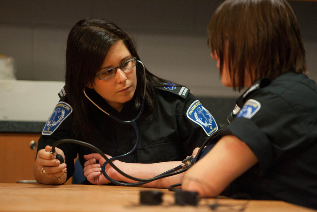 辅助医学专业的学生用听诊器互相检查脉搏