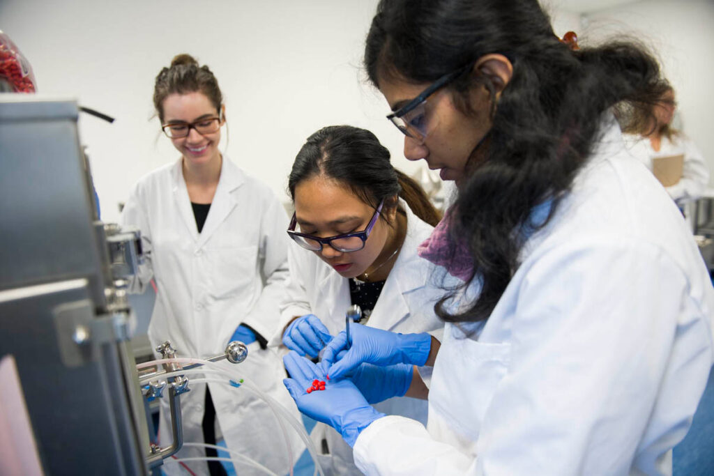 药科学生在实验室里观察他们刚刚创建的药物胶囊