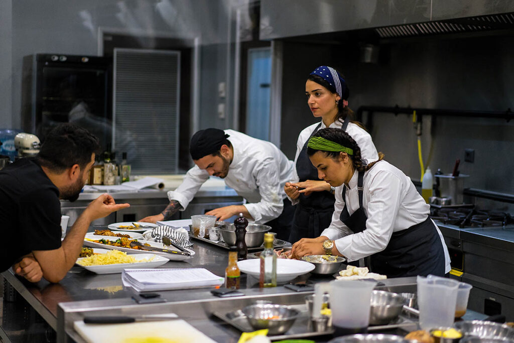 烹饪教练与在厨房做饭的学生交谈