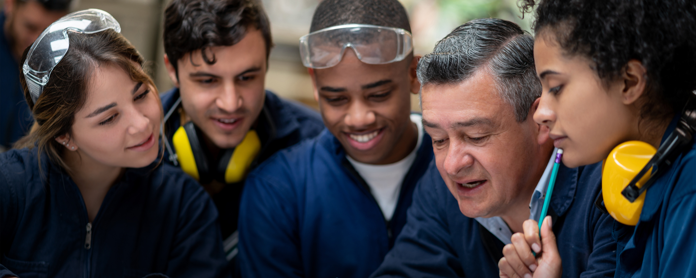 讲师在机械车间与学生交谈