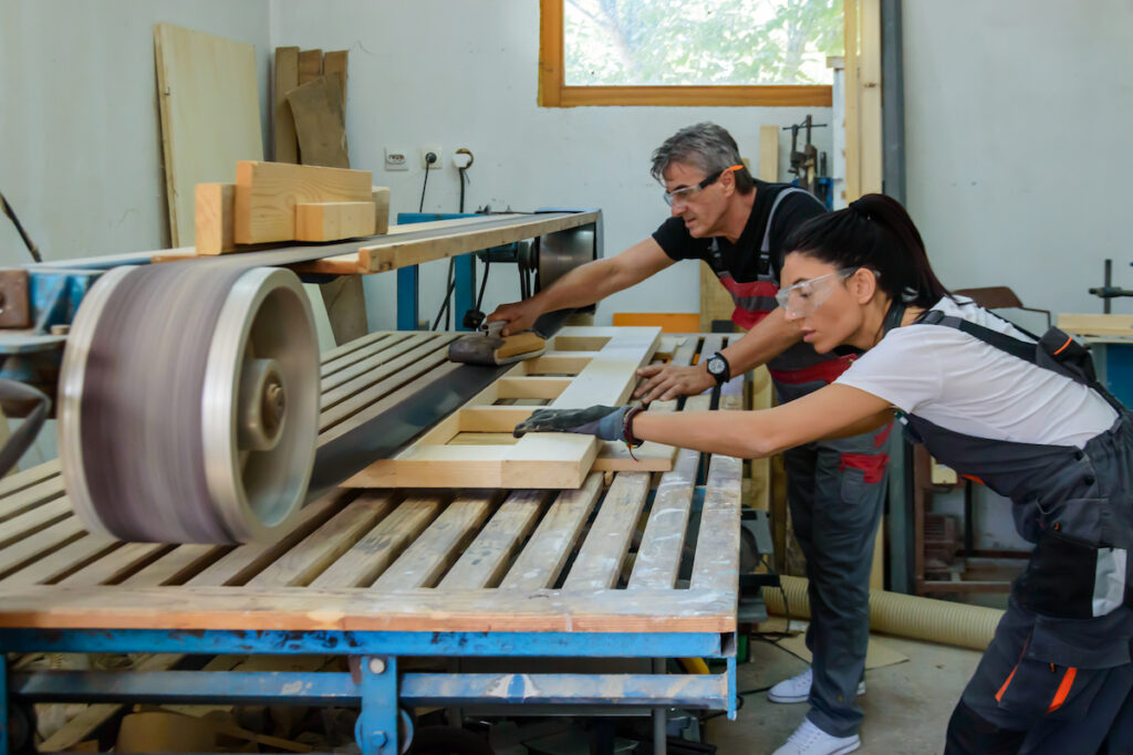 两个人打磨一大块木头