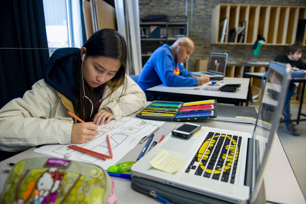 一名平面设计学生在 e8体育 的教室里从事插画项目
