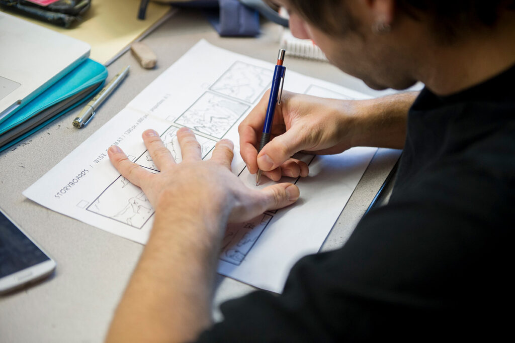 e8体育 的一名平面设计学生在教室里绘制故事板