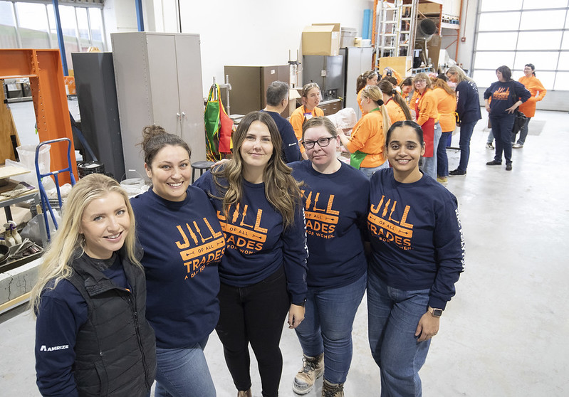 五个人站着对着镜头微笑。