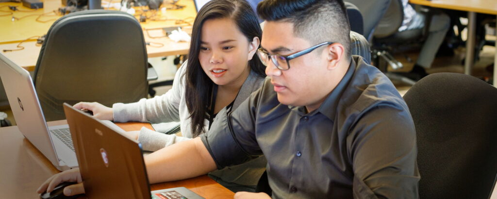 年轻男女看着笔记本电脑