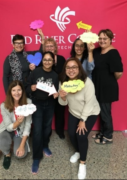 人们在e8体育的背景前举着各种语言的欢迎标语。