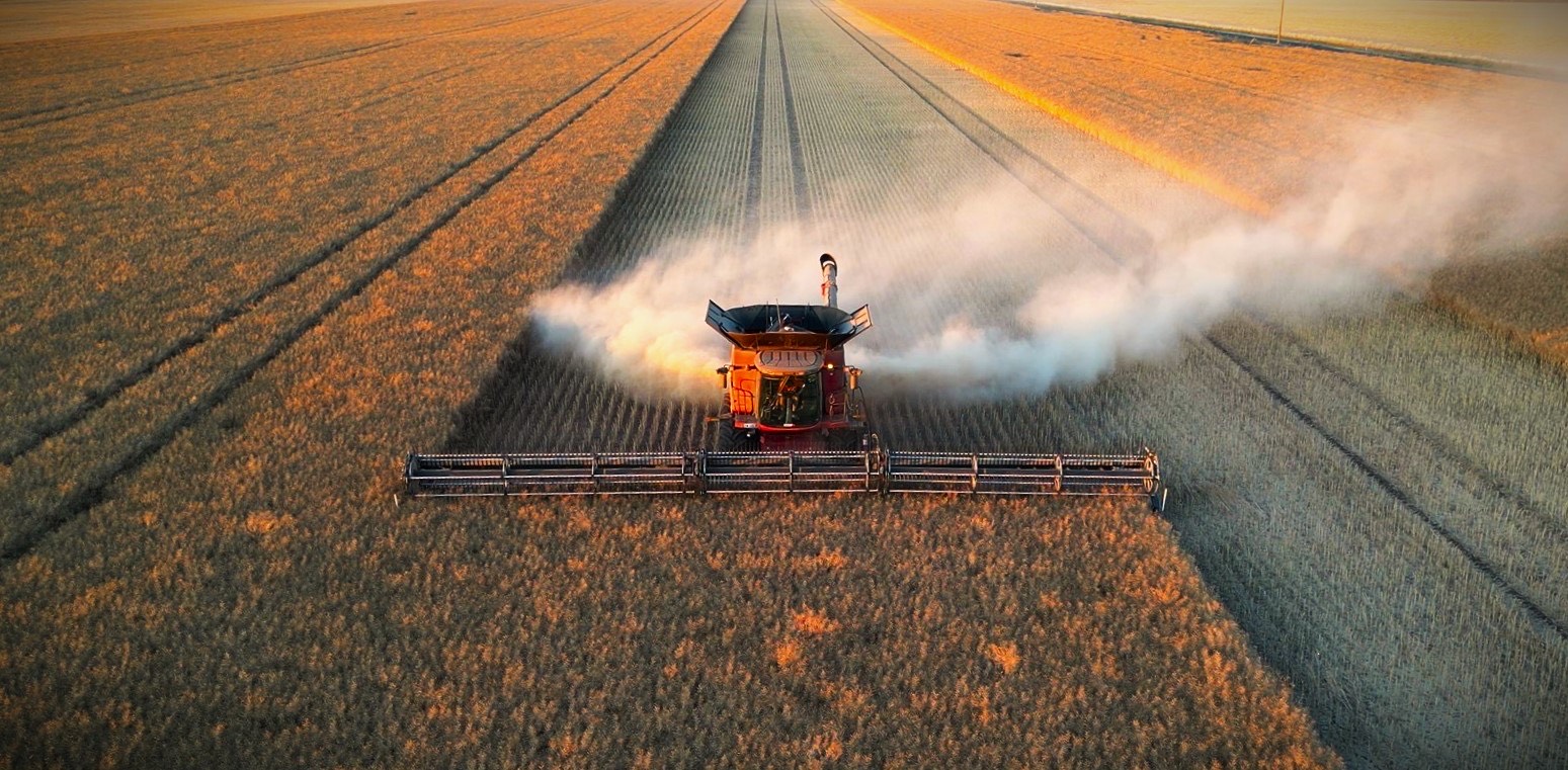 联合拖拉机在田间收割庄稼的俯视图。