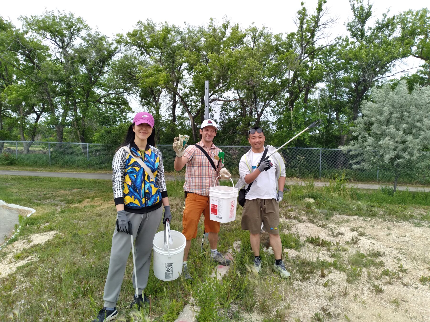学生们拿着水桶和除草机到外面