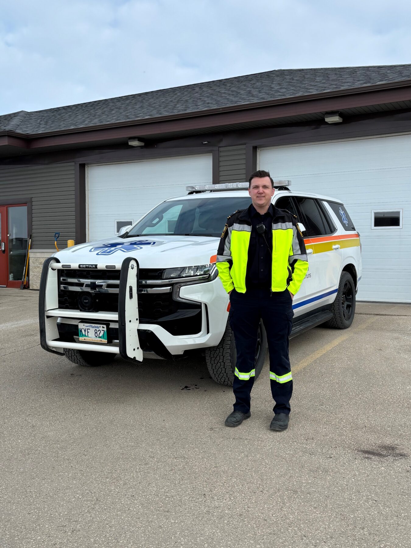 高级护理辅助医学毕业生 Nick Bourgeois 穿着制服站在救护车前