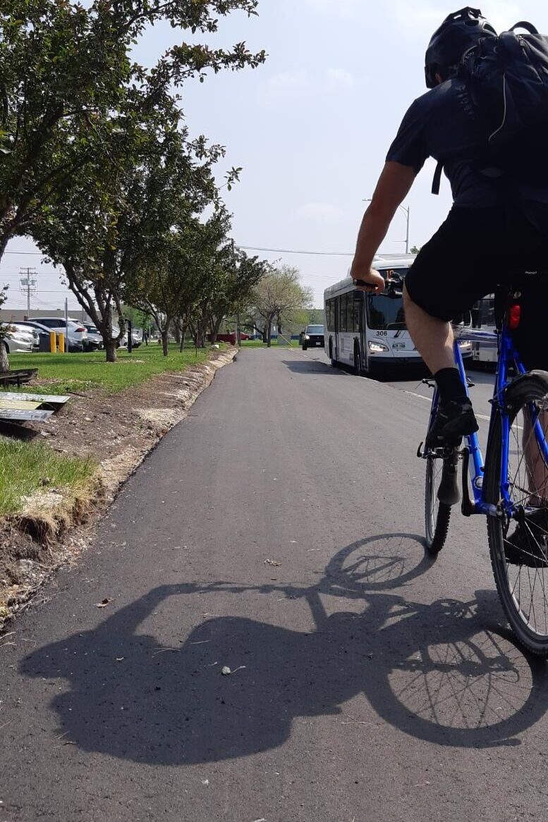 骑自行车的人上下班时经过公交车