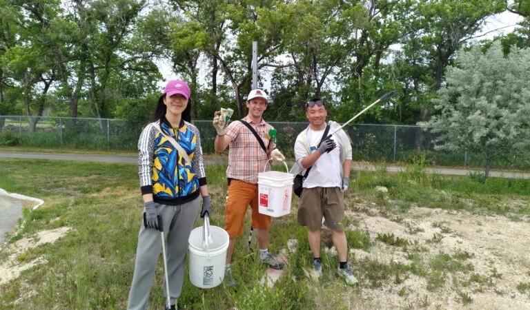 教职员工和学生在清洁e8体育网场地时拿着水桶和工具合影
