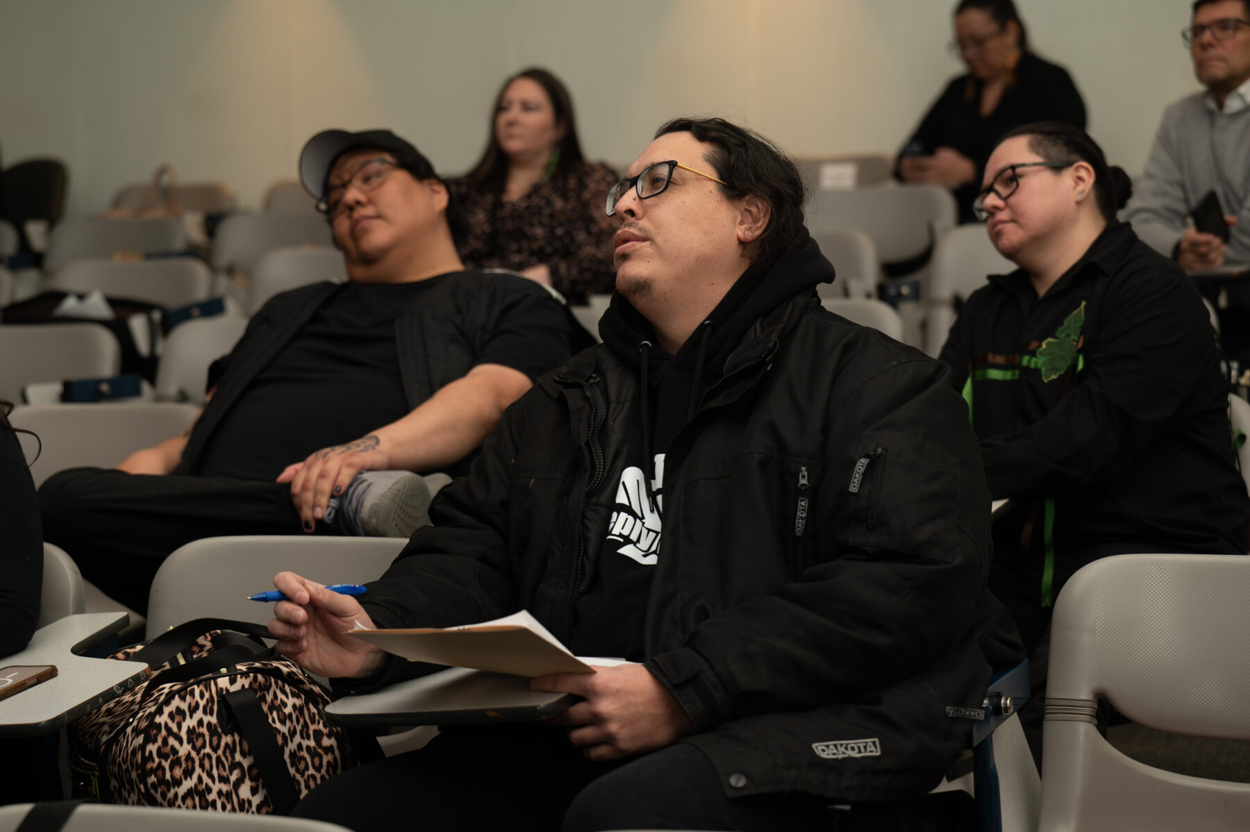 投球比赛中，裁判在观众中间拿着便笺本和纸