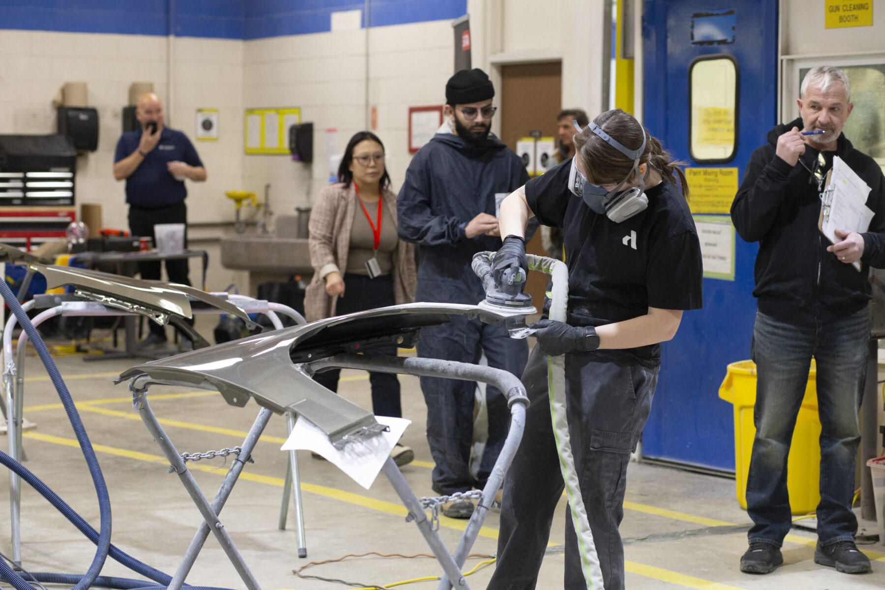 一个人准备汽车面板进行喷漆