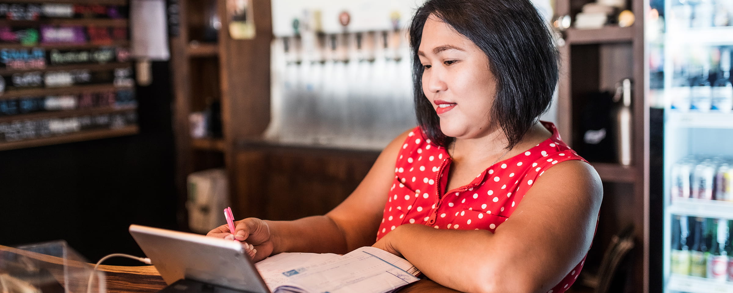 女人一边看平板电脑一边做笔记
