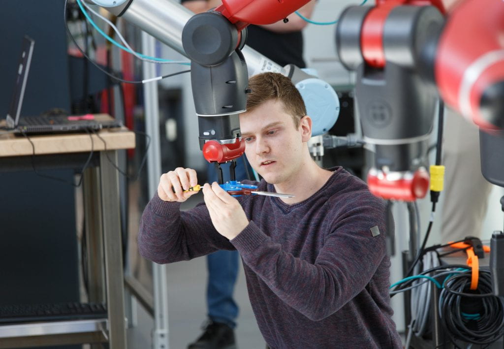 男学生调整协作机器人