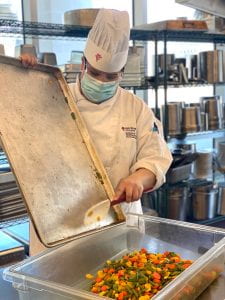 RRC 烹饪技能学生 Zoey Gladu 正在准备蔬菜