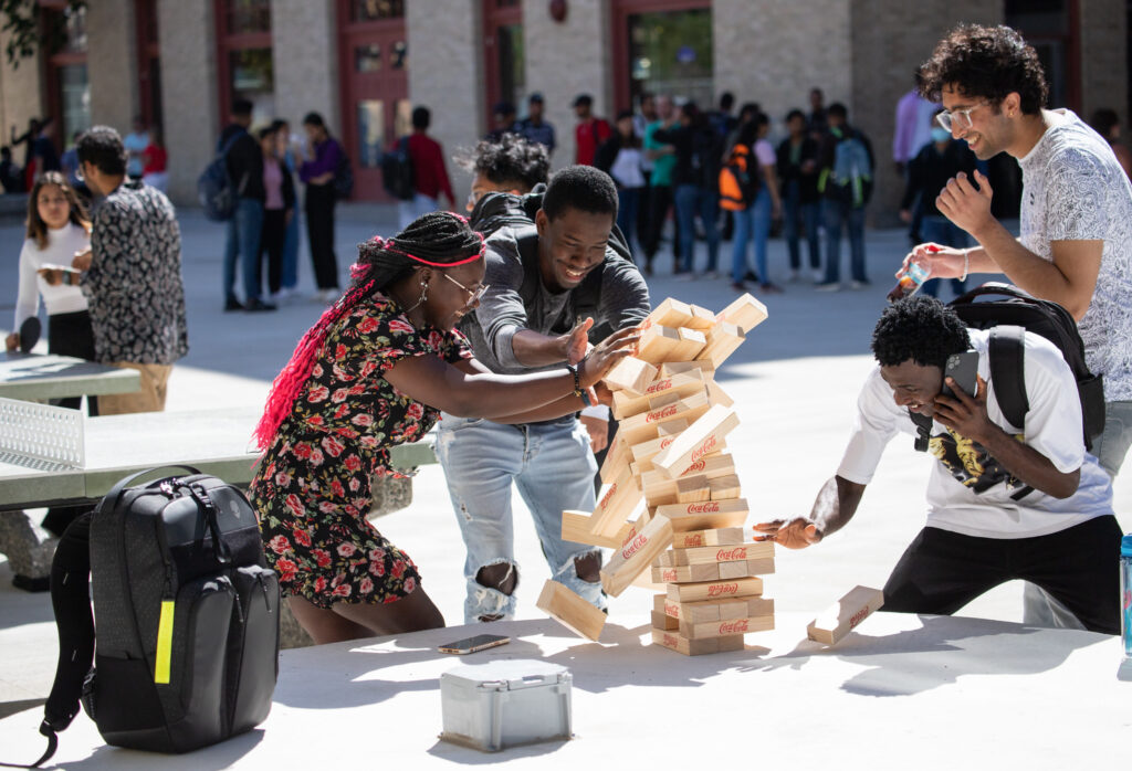 不同的学生群体在户外玩叠叠乐