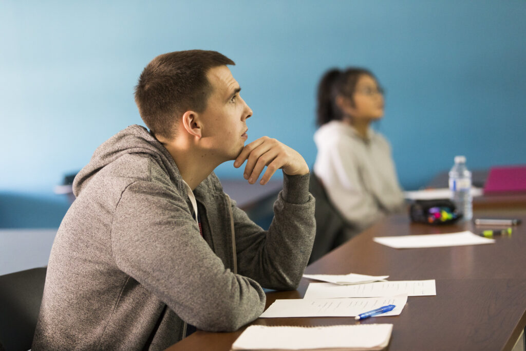 男学生（前景）和女学生（背景）正在听老师讲课