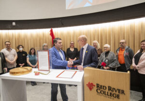 RRC Polytech president Fred Meier shakes hands with MGEU president Kyle Ross.