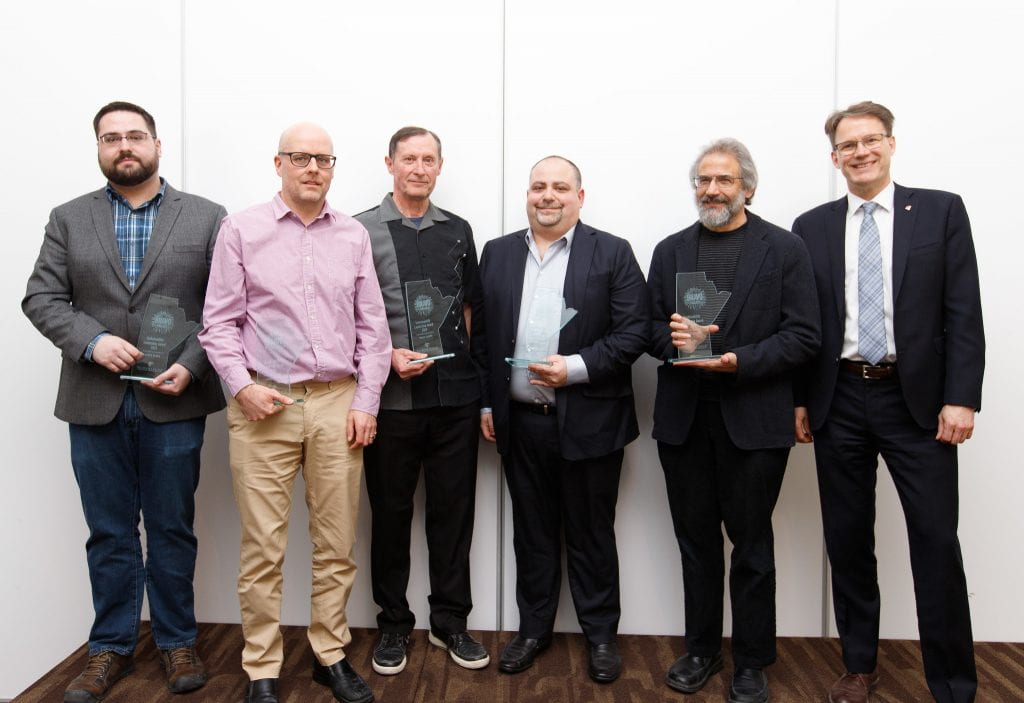 机械工程技术系的五位男士站在学院院长旁边，自豪地举起 BRAVO 奖。